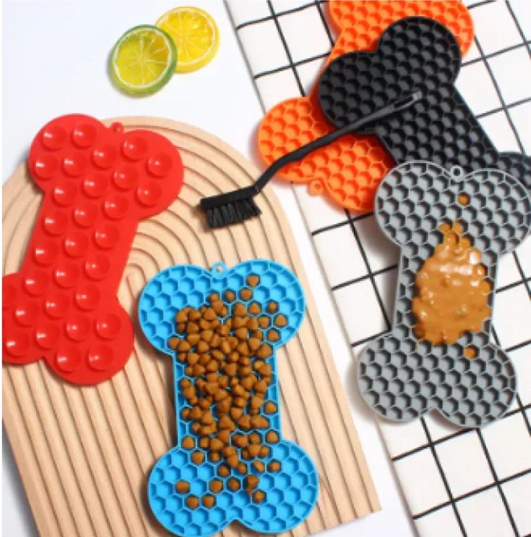 Dog licking peanut butter from silicone lick mat